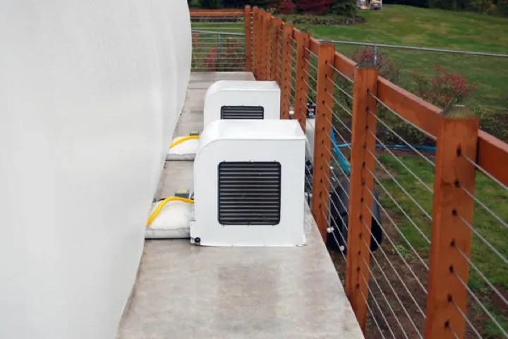 Two white blower units on a concrete deck alongside a pool dome enclosure