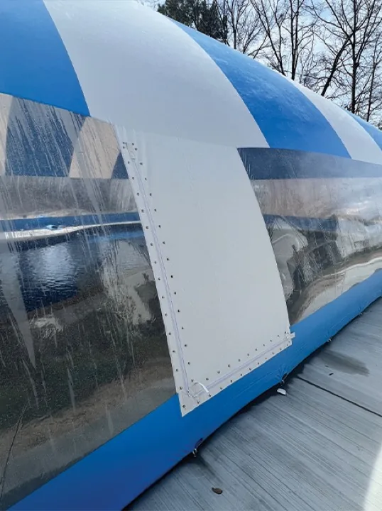Zippered entry panel on the wall of a blue and white striped pool dome enclosure, closed