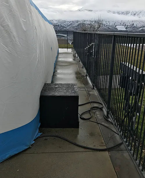 Heater unit set on the deck alongside a blue and white pool dome enclosure