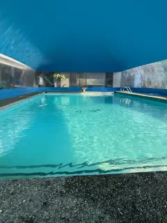 Pool lit from below at night inside a pool dome enclosure
