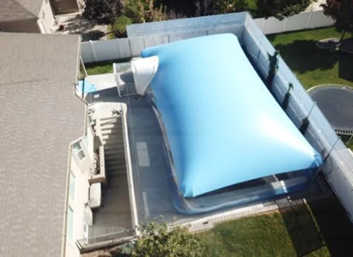 Solid blue pool dome enclosure seen from the roofline above a backyard